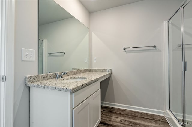 bathroom with vanity, hardwood / wood-style flooring, and a shower with shower door