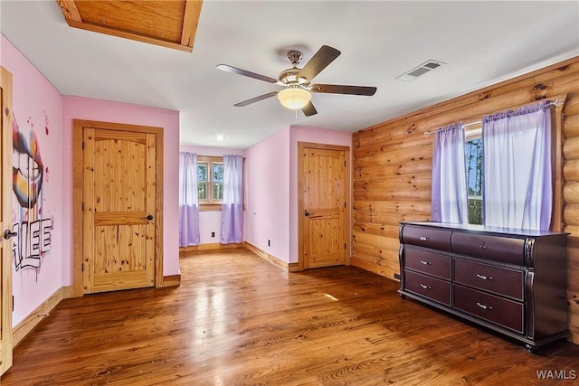 20442 Old Jasper Rd, Northport, AL 35475 - unfurnished bedroom with rustic walls, visible vents, baseboards, and wood finished floors