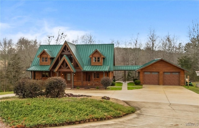 log-style house featuring a standing seam roof, a porch, concrete driveway, and metal roof