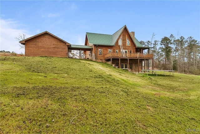 20442 Old Jasper Rd, Northport, AL 35475 - rear view of property with a wooden deck, a yard, a chimney, a trampoline, and metal roof