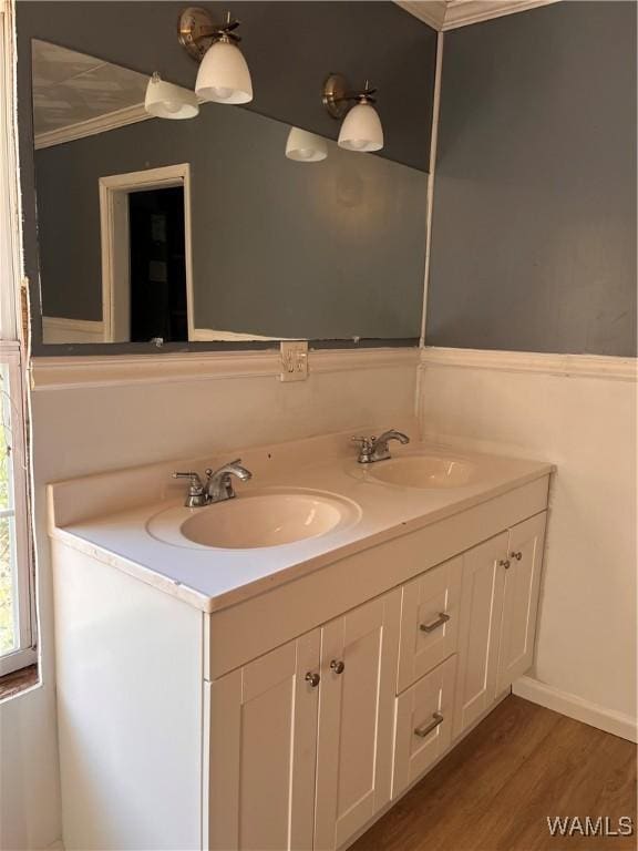 bathroom featuring vanity, wood-type flooring, and ornamental molding