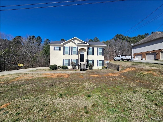 bi-level home featuring a garage and a front lawn