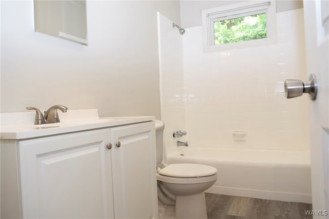 full bathroom featuring vanity, toilet, wood-type flooring, and tiled shower / bath