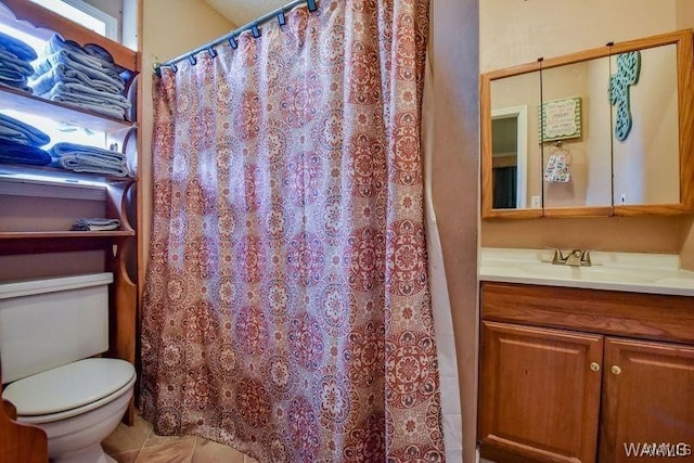 bathroom with tile patterned flooring, vanity, and toilet