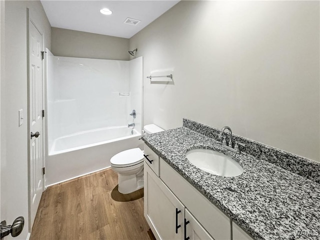 full bathroom with vanity, toilet, shower / washtub combination, wood finished floors, and visible vents