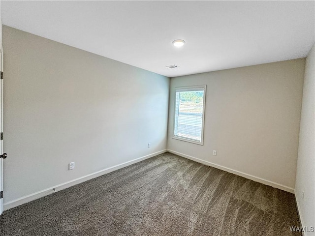 empty room featuring visible vents, baseboards, and carpet floors