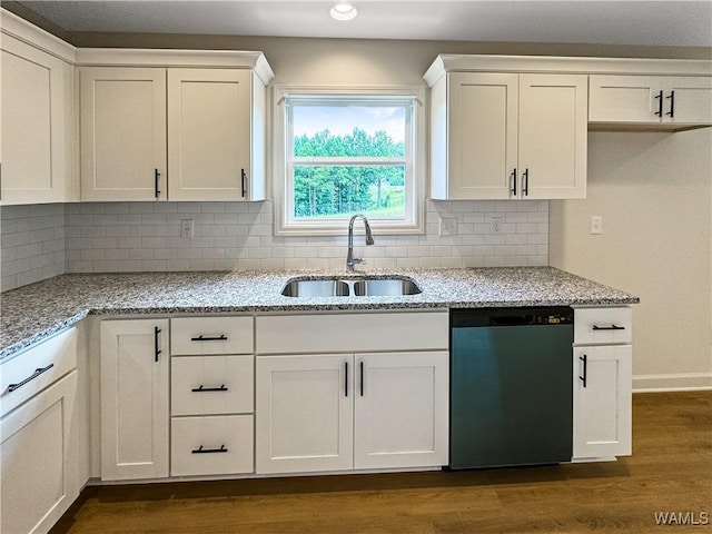 kitchen featuring light stone countertops, a sink, dishwasher, white cabinetry, and dark wood-style floors