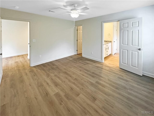 unfurnished bedroom with baseboards, ceiling fan, wood finished floors, and visible vents