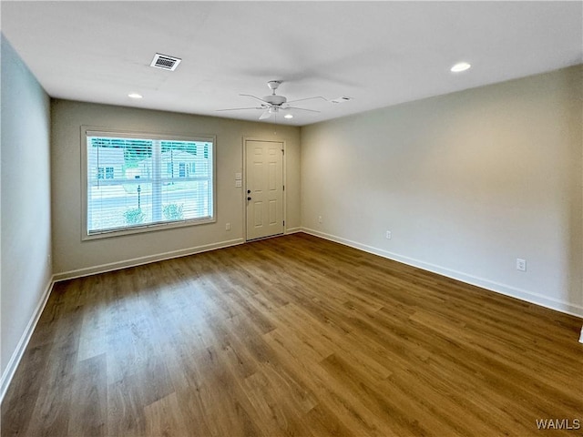 unfurnished room with a ceiling fan, baseboards, visible vents, and wood finished floors