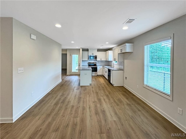 kitchen with visible vents, baseboards, white cabinets, and stainless steel appliances