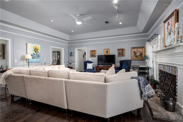 1137 Germantown Rd, Tuscaloosa, AL 35406 - living room featuring ceiling fan, dark wood-style flooring, a decorative wall, a fireplace, and a raised ceiling