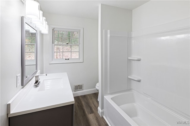 full bathroom with toilet, hardwood / wood-style flooring, shower / washtub combination, and vanity