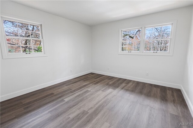 spare room with wood finished floors and baseboards