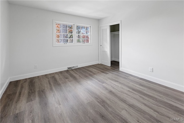 unfurnished bedroom with a closet and hardwood / wood-style flooring