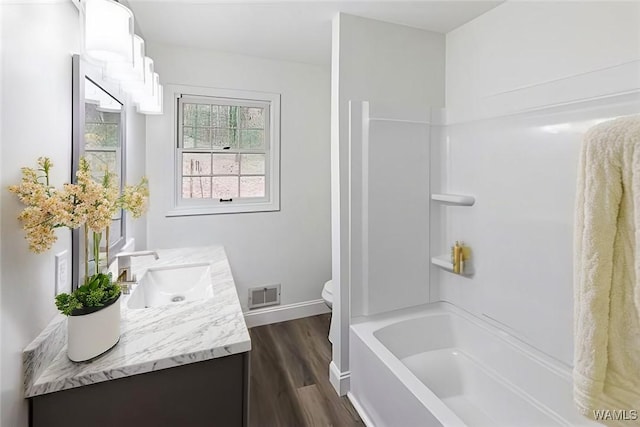 bathroom featuring visible vents, toilet, wood finished floors, baseboards, and vanity