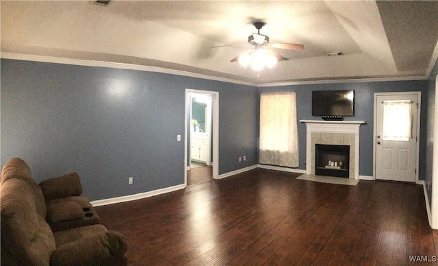 living area with a tiled fireplace, ornamental molding, a ceiling fan, baseboards, and hardwood / wood-style flooring