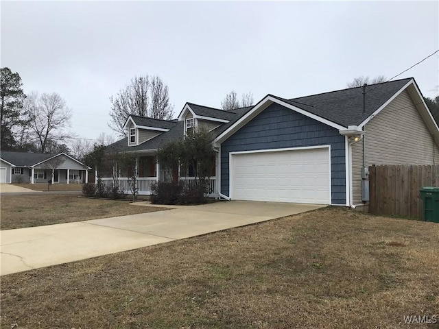 view of front of house featuring driveway, an attached garage, covered porch, fence, and a front yard