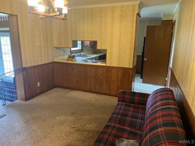 145 Lecroy Cir, Brent, AL 35034 - kitchen featuring a chandelier, wallpapered walls, a wainscoted wall, crown molding, and wood walls