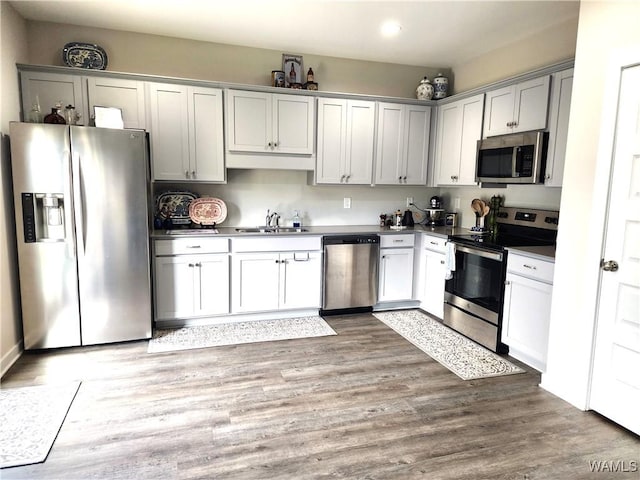 15525 Tide Water Ter, Brookwood, AL 35444 - kitchen with appliances with stainless steel finishes, a sink, recessed lighting, dark countertops, and light wood-style flooring