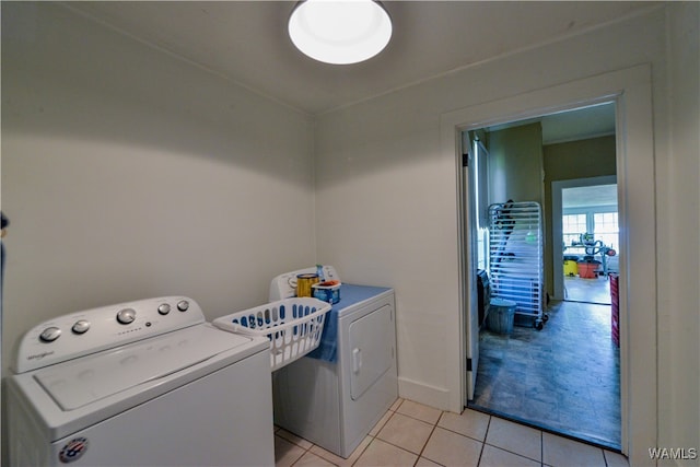 laundry area featuring washing machine and dryer and light tile patterned floors