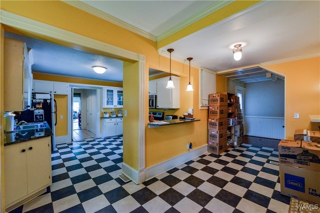 kitchen featuring sink, white cabinetry, ornamental molding, and hanging light fixtures