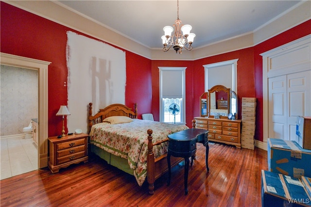 bedroom featuring a chandelier, dark hardwood / wood-style flooring, ensuite bathroom, and ornamental molding