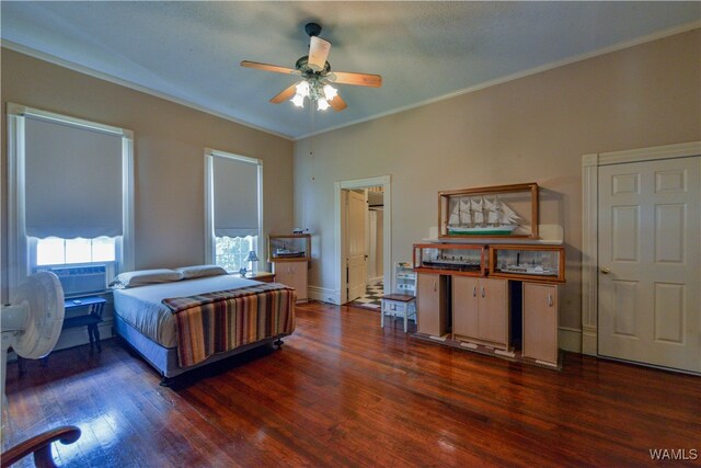 bedroom with ceiling fan, ornamental molding, and dark wood-type flooring