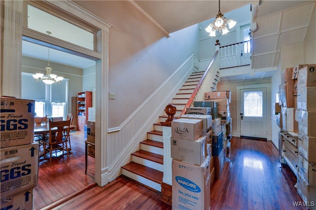 staircase featuring wood-type flooring, an inviting chandelier, and plenty of natural light