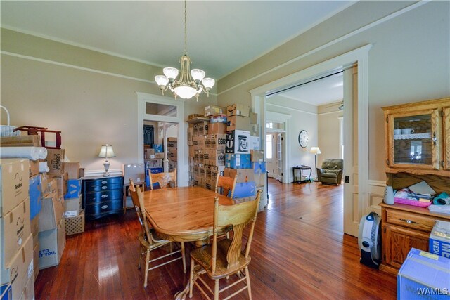 dining space with dark wood-type flooring and a chandelier