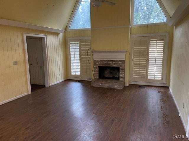 unfurnished living room featuring ceiling fan, high vaulted ceiling, dark hardwood / wood-style floors, and a brick fireplace