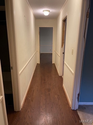 corridor with dark hardwood / wood-style floors and ornamental molding