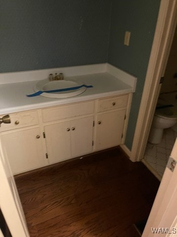 bathroom with hardwood / wood-style floors, vanity, and toilet