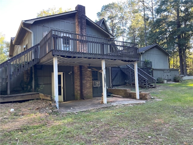 back of property featuring a wooden deck, a patio area, and a yard