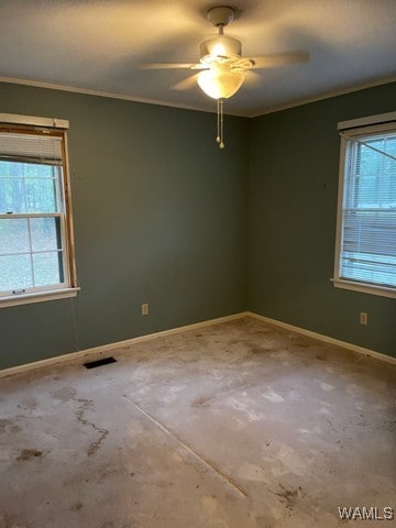 carpeted spare room with ornamental molding, ceiling fan, and a healthy amount of sunlight