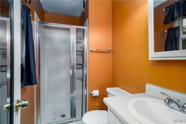 bathroom featuring toilet, an enclosed shower, a textured ceiling, and vanity