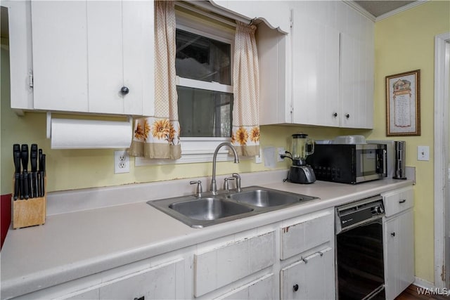 kitchen with white cabinets, black dishwasher, ornamental molding, and sink