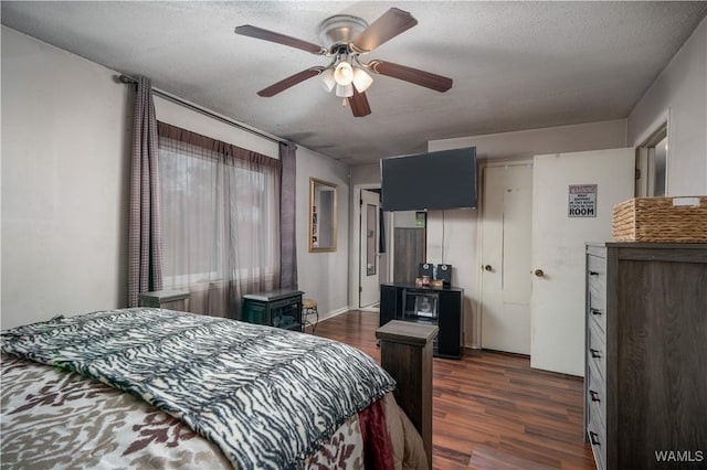 bedroom with ceiling fan, dark hardwood / wood-style flooring, and a textured ceiling