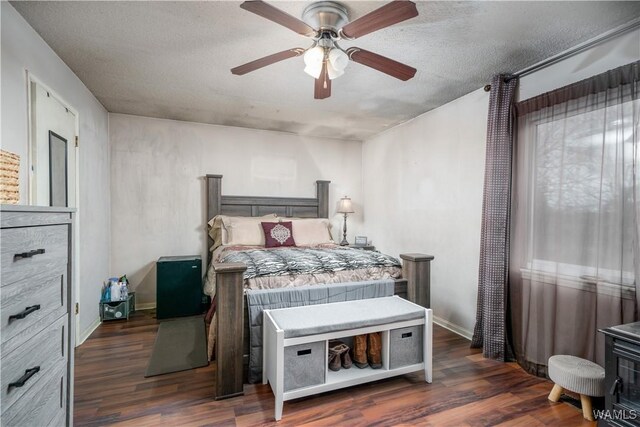 bedroom with ceiling fan, dark hardwood / wood-style flooring, and a textured ceiling