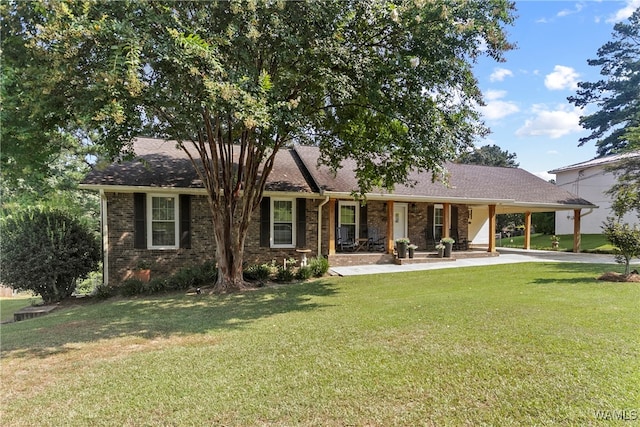 view of front of property featuring covered porch, a carport, and a front lawn