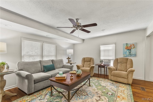 living room featuring a textured ceiling, a wealth of natural light, dark wood-type flooring, and ceiling fan