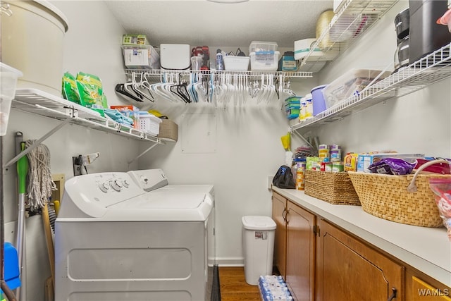 laundry room with washing machine and dryer, dark hardwood / wood-style flooring, cabinets, and a textured ceiling