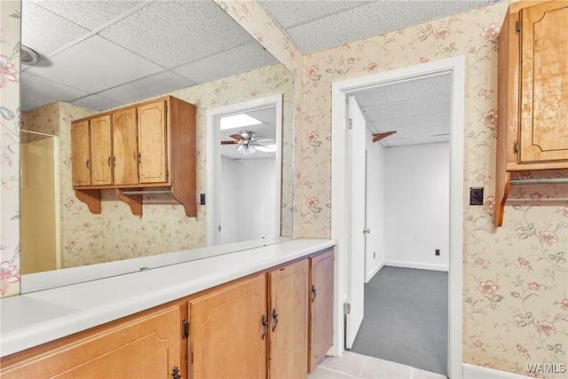 interior space with a drop ceiling and ceiling fan