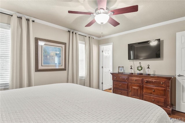 bedroom with multiple windows, dark hardwood / wood-style floors, ceiling fan, and ornamental molding