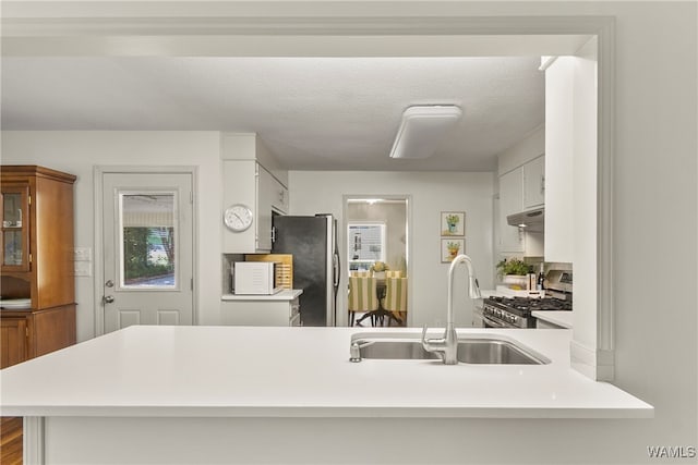 kitchen featuring kitchen peninsula, sink, white cabinetry, and stainless steel appliances