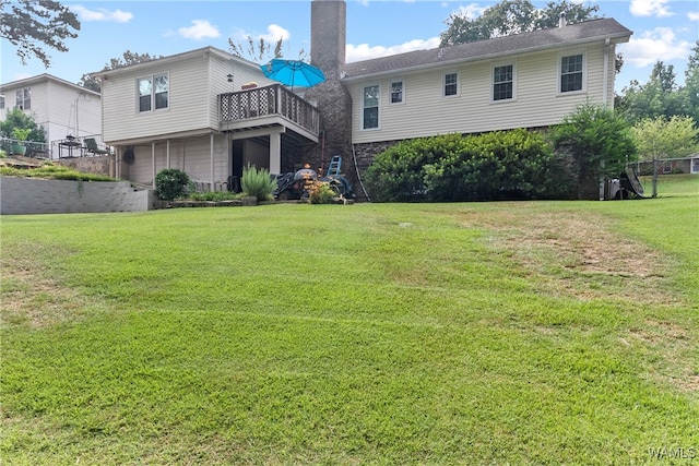 back of house featuring a lawn and a balcony