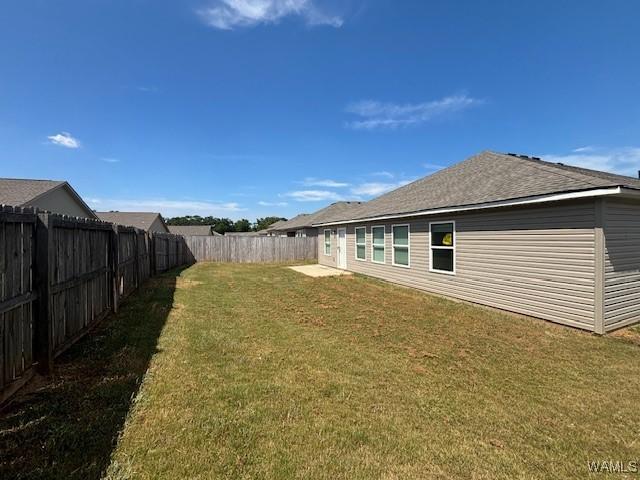 back of house featuring a fenced backyard and a yard