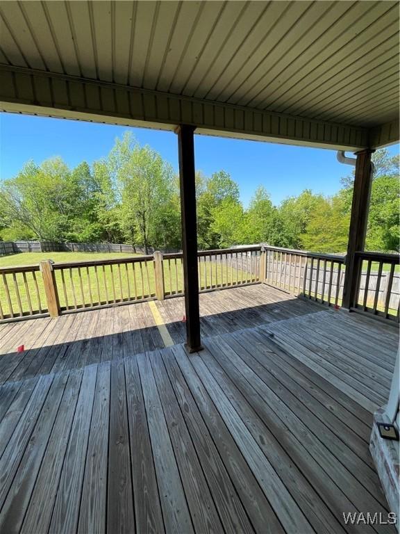 deck with a lawn and a fenced backyard
