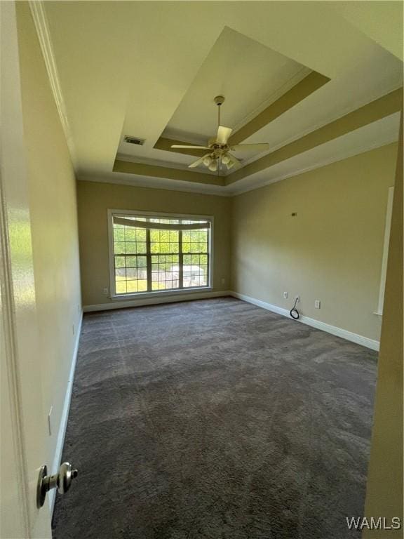 unfurnished room featuring baseboards, ceiling fan, a tray ceiling, and visible vents