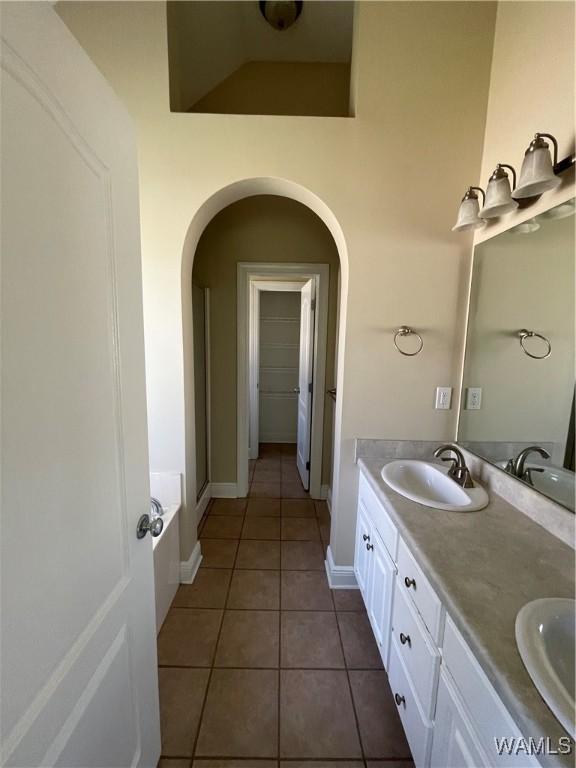 full bathroom featuring tile patterned flooring, a sink, and double vanity