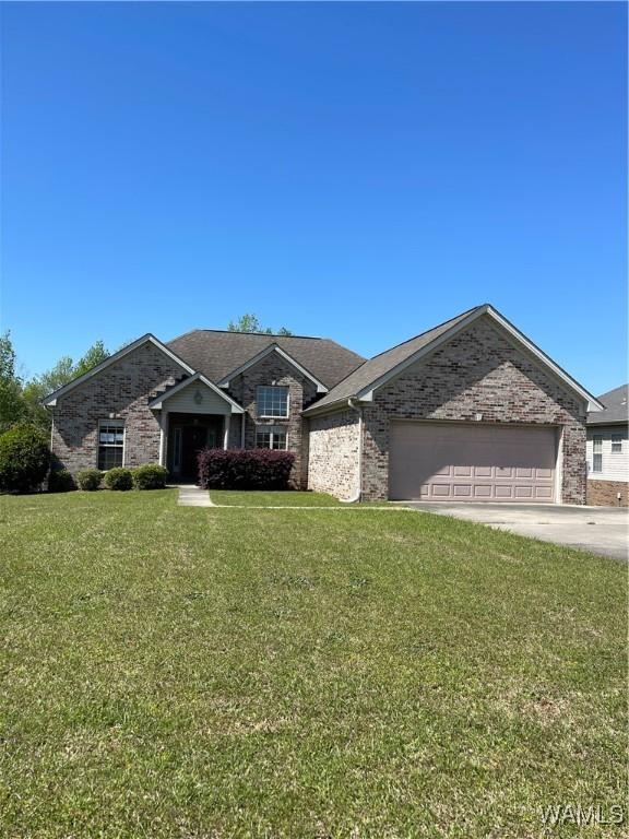 view of front of home featuring concrete driveway, brick siding, a front lawn, and a garage